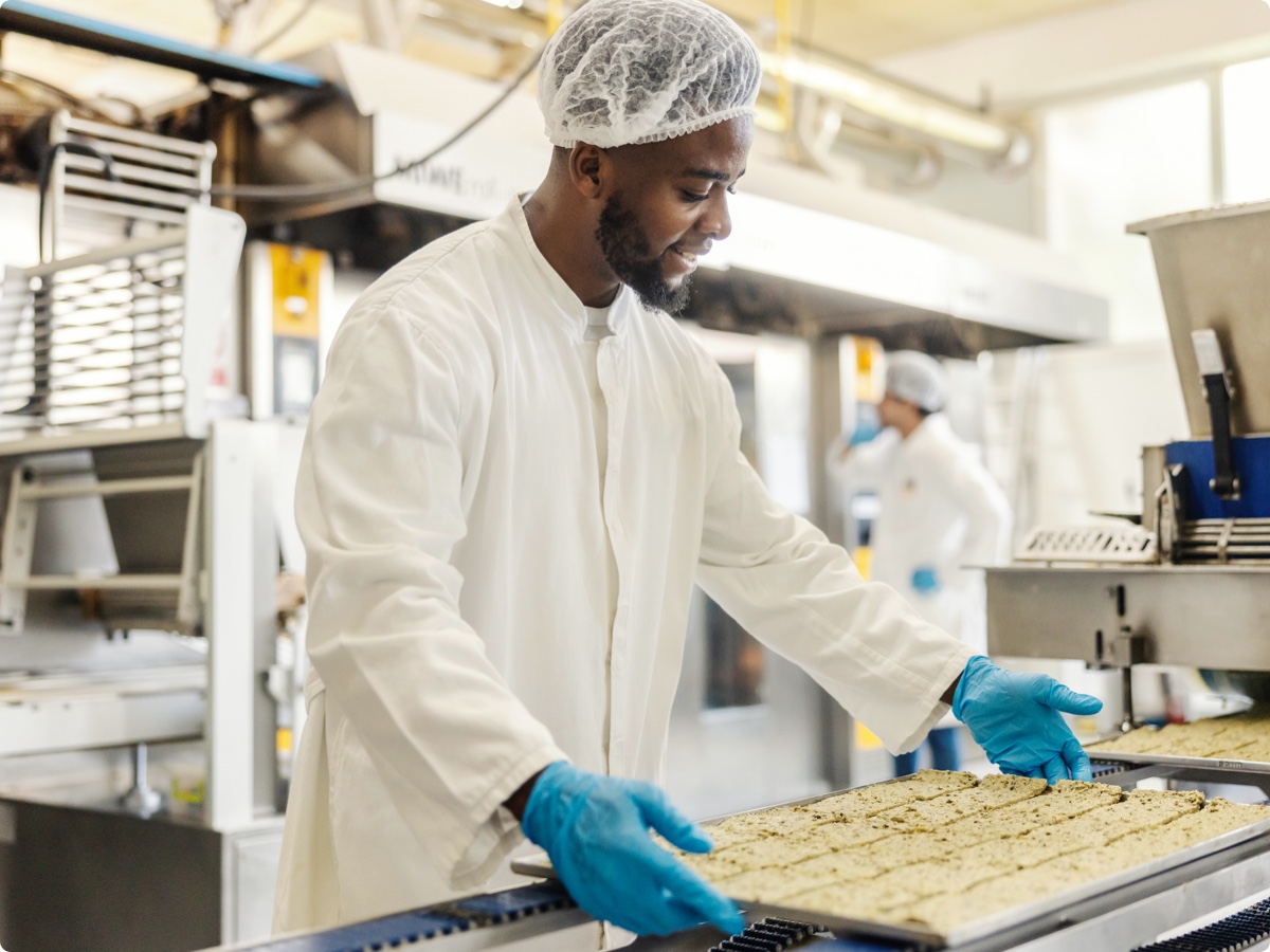 Diverse-food-factory-baker-putting-raw-biscuits-lg